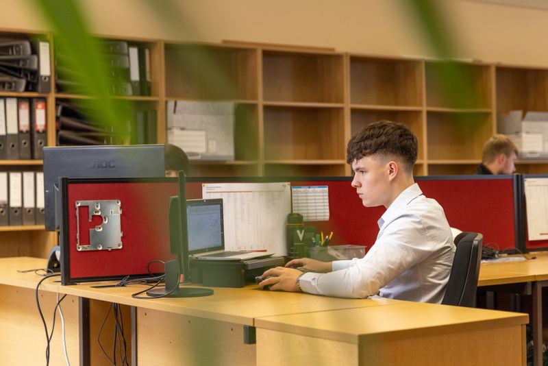 Joven trabajando en computadora en su oficina