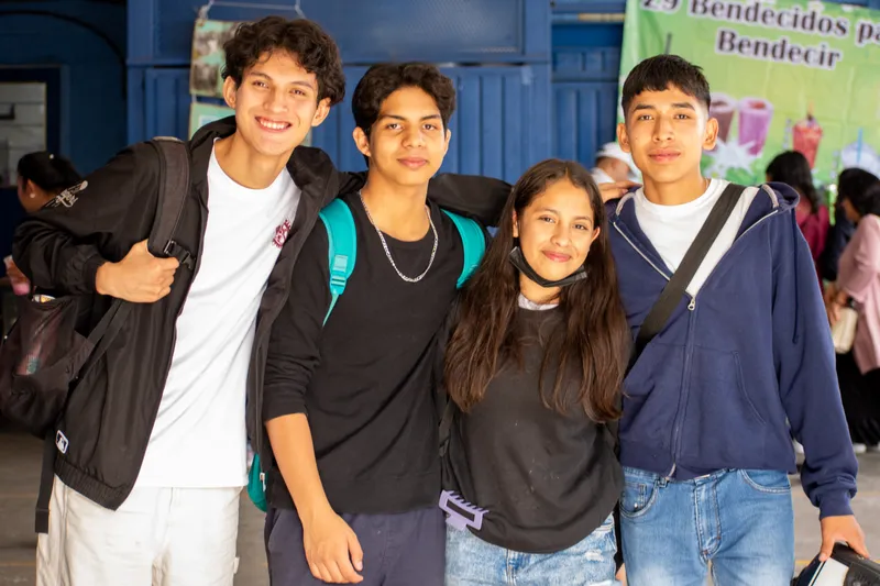 Grupo alegre de adolescentes sonriendo juntos en la institución educativa